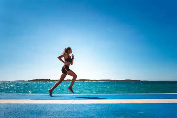Woman running showing strong leg muscle Abbotsbury